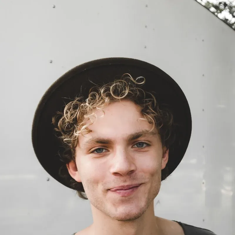 man standing near white wall